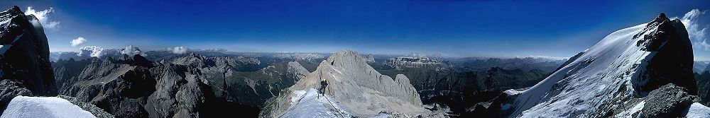 360°-Panorama der Dolomiten vom Westgrat der Marmolata. Links und rechts der Gipfel Punta Penia, am Horizont Palagruppe, Latemar, Rosengarten, Langkofel, Sella und Ampezzaner Dolomiten.