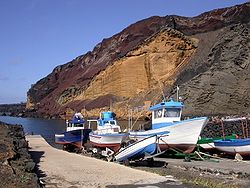 Fischerhafen auf Linosa - im Hintergrund verschiedene Schichten vulkanischen Gesteins