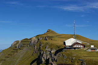 Blick hinauf zum Gipfel des Männlichen mit UNESCO-Weg von der Bergstation der Gondelbahn Grindelwald-Männlichen aus. Im Vordergrund die Bergstation der Luftseilbahn Wengen-Männlichen.