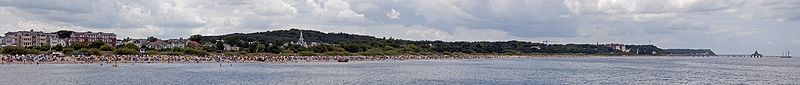 Tourismus auf der Insel Usedom: Blick von der Ahlbecker Seebrücke über den Strand Richtung Heringsdorf und Bansin mit den Seebrücken