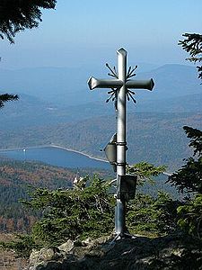 Gipfelkreuz des Kleinen Rachels mit Blick auf die Trinkwassertalsperre Frauenau