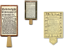 Nachbildungen typischer Buchstabentafeln: links ein frühes, in der Mitte ein späteres englisches Hornbuch; rechts ein Battledore aus Karton.