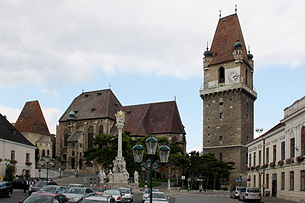 Perchtoldsdorfer Hauptplatz: links die Martinskirche, mittig die Pfarrkirche, rechts der Wehrturm und im Vordergrund die Dreifaltigkeits-(Pest-)säule
