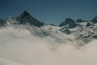 Blick von oberhalb der Bielerhöhe über den Silvrettastausee (im Nebel) auf Hohes Rad (links) und die beiden Buine weiter rechts