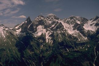 Bockkarkopf (Der Berg im rechten Bildbereich zwischen den beiden ausgeprägten Scharten) von Nordwesten. Weitere Gipfel von links: Trettachspitze, Mädelegabel, Hochfrottspitze. Ganz rechts der Wilde Mann
