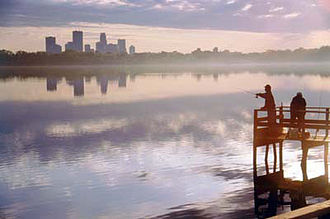 Zwei Angler am Lake Calhoun; im Hintergrund die Skyline von Minneapolis