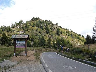 Passhöhe mit Hinweisschild, Sicht Richtung Osten